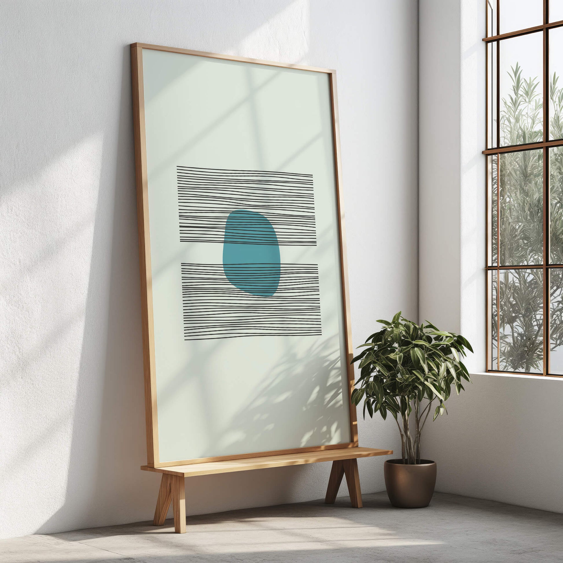 Azure Balance Print framed in light wood, displayed on a wooden stand near a potted plant with natural light streaming in