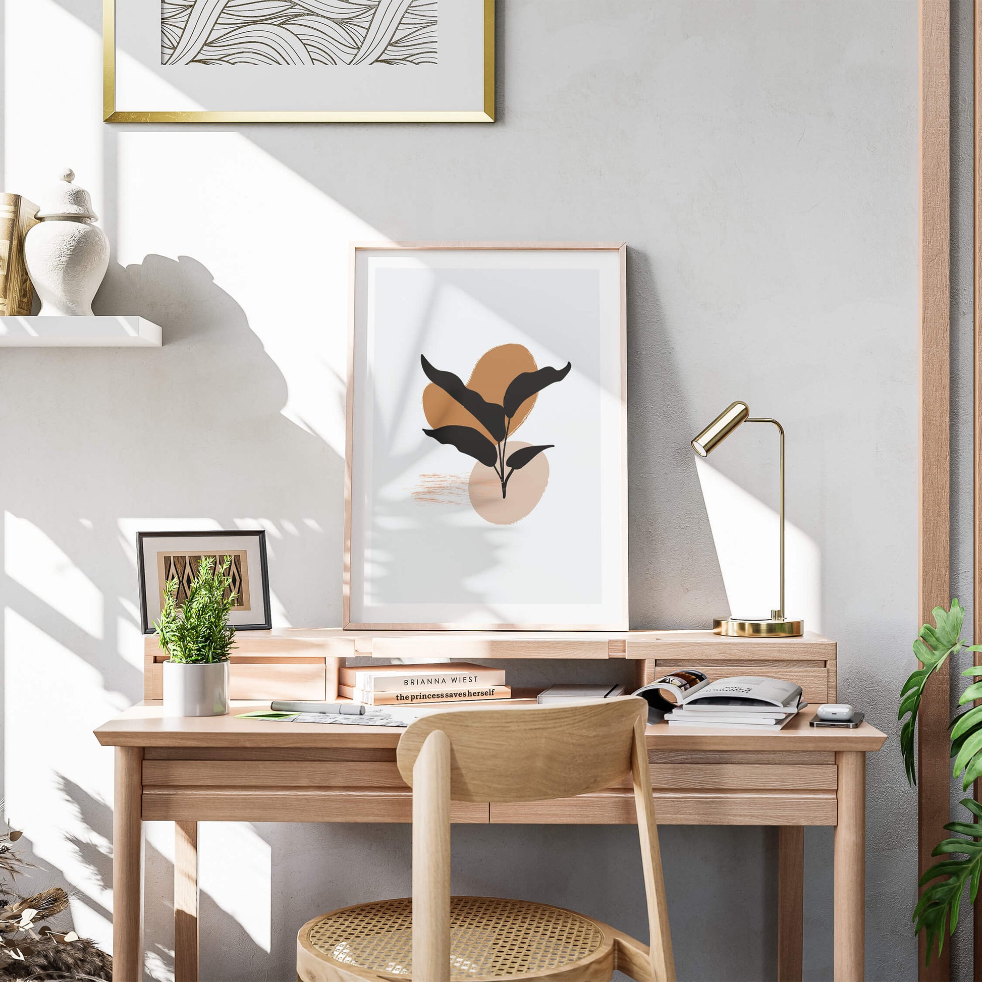 Elegant black leaf abstract print framed on a wooden desk with natural sunlight enhancing its earthy palette.
