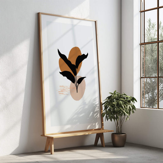 Large black leaf abstract print with a wooden frame displayed on a stand in a bright, modern interior.
