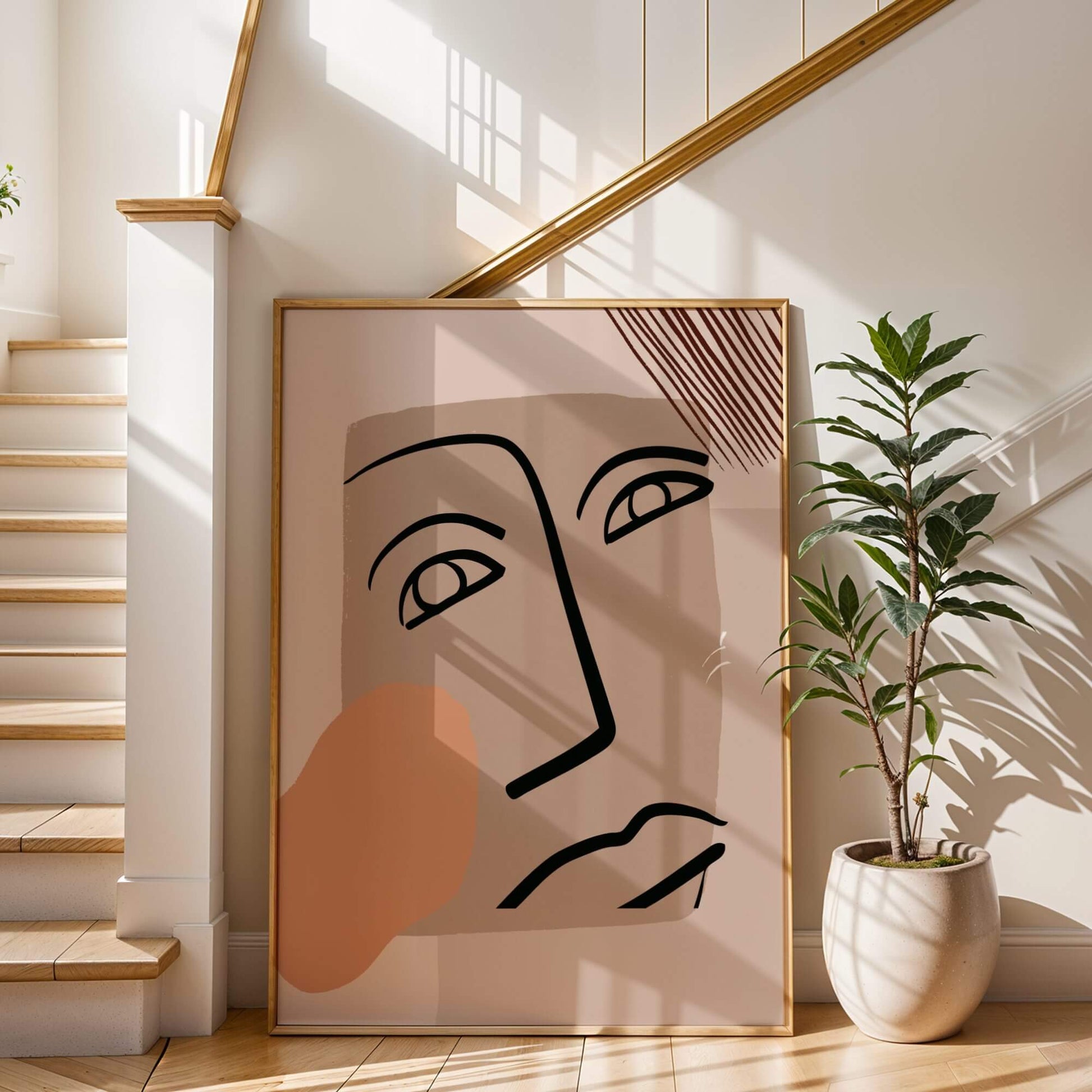 Large bold gaze abstract face print leaning against a staircase, framed elegantly with warm tones.
