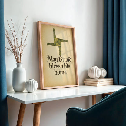 Framed Celtic mythology wall print featuring Brigid’s Cross on a white desk near blue curtains, styled for a cosy home setting.