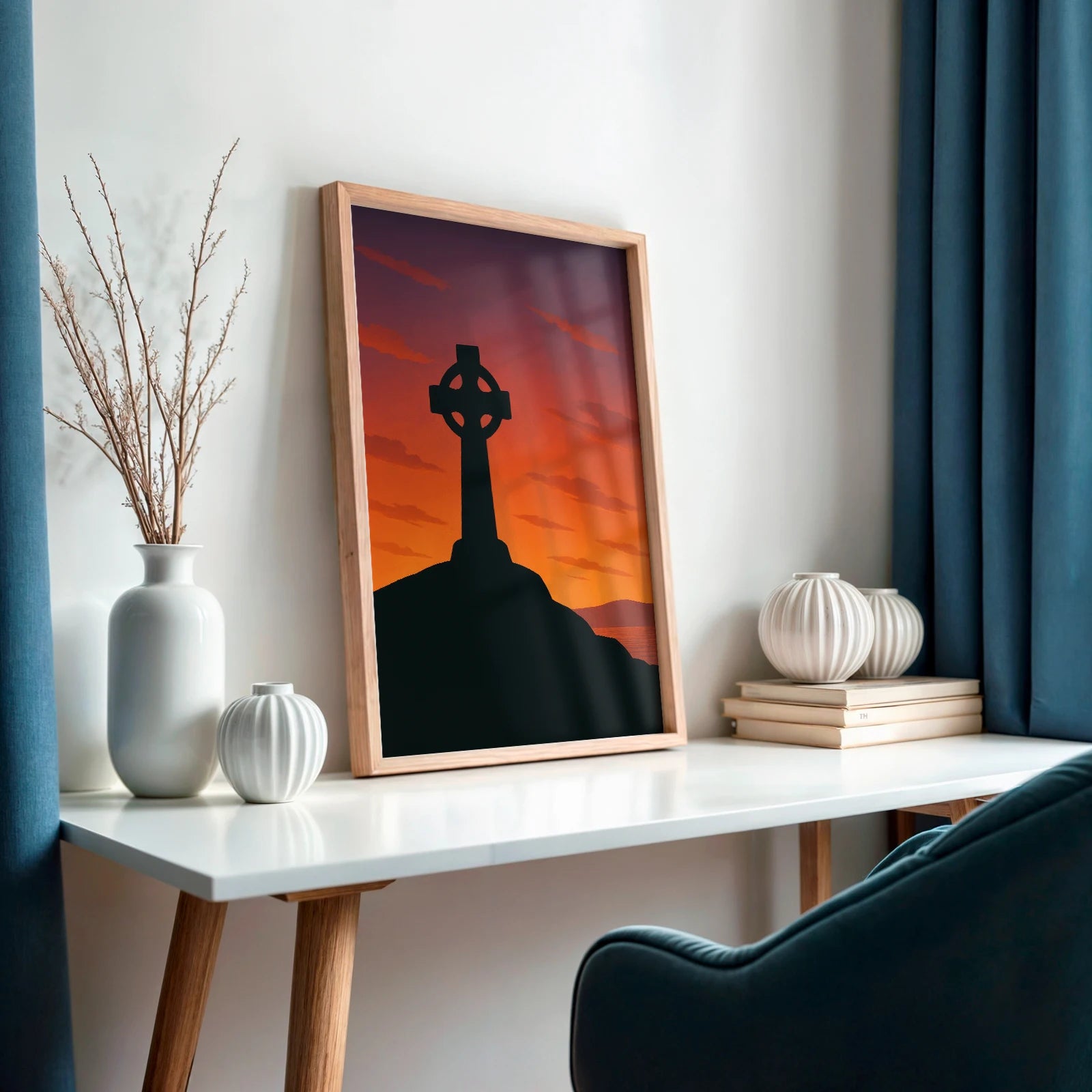 Angled view of Celtic Cross print in light wood frame on a white desk, surrounded by simple vases – Irish folklore theme.