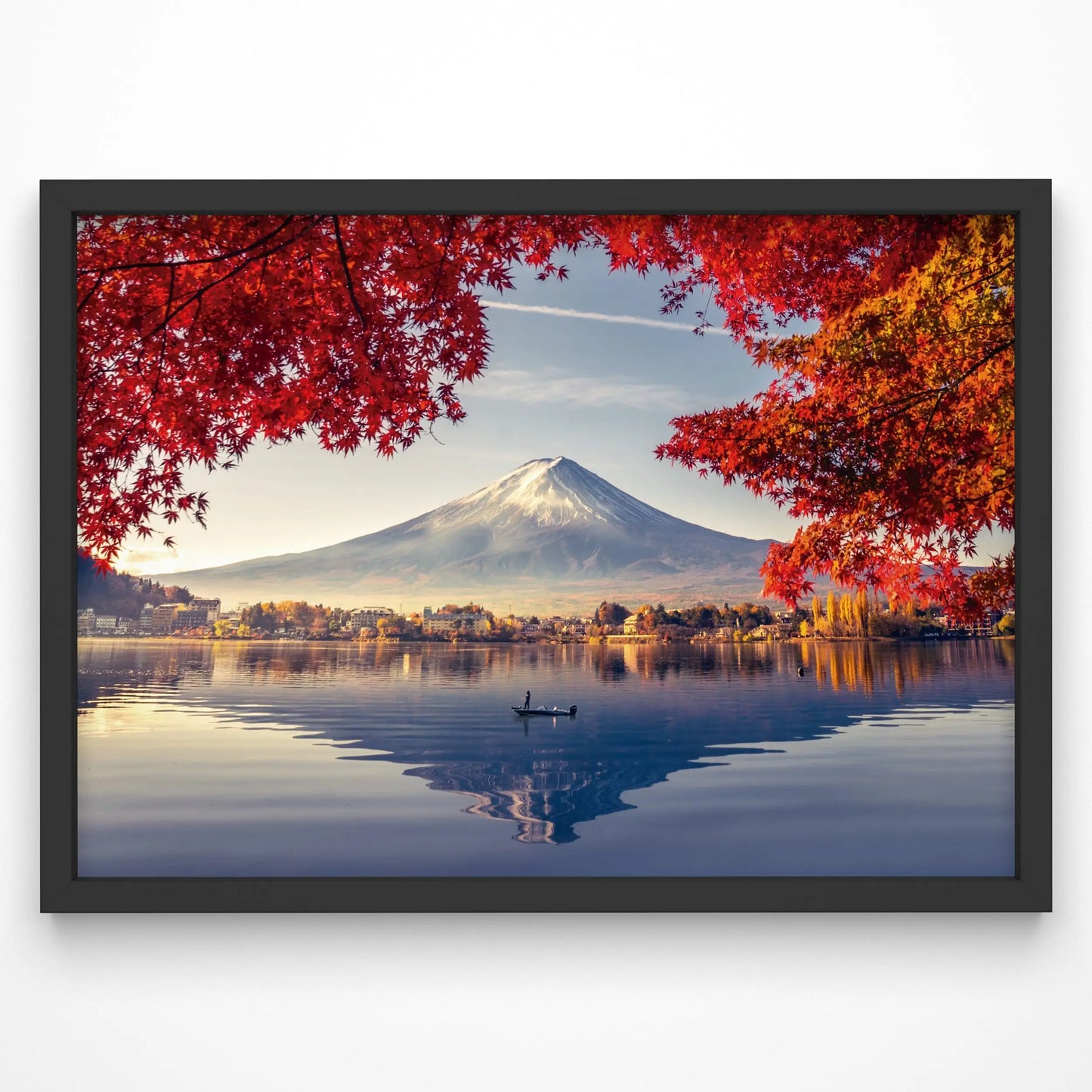 A breathtaking view of Mount Fuji framed by vibrant autumn maple leaves, reflecting in a tranquil lake. A lone boat drifts across the water, adding to the peaceful atmosphere.