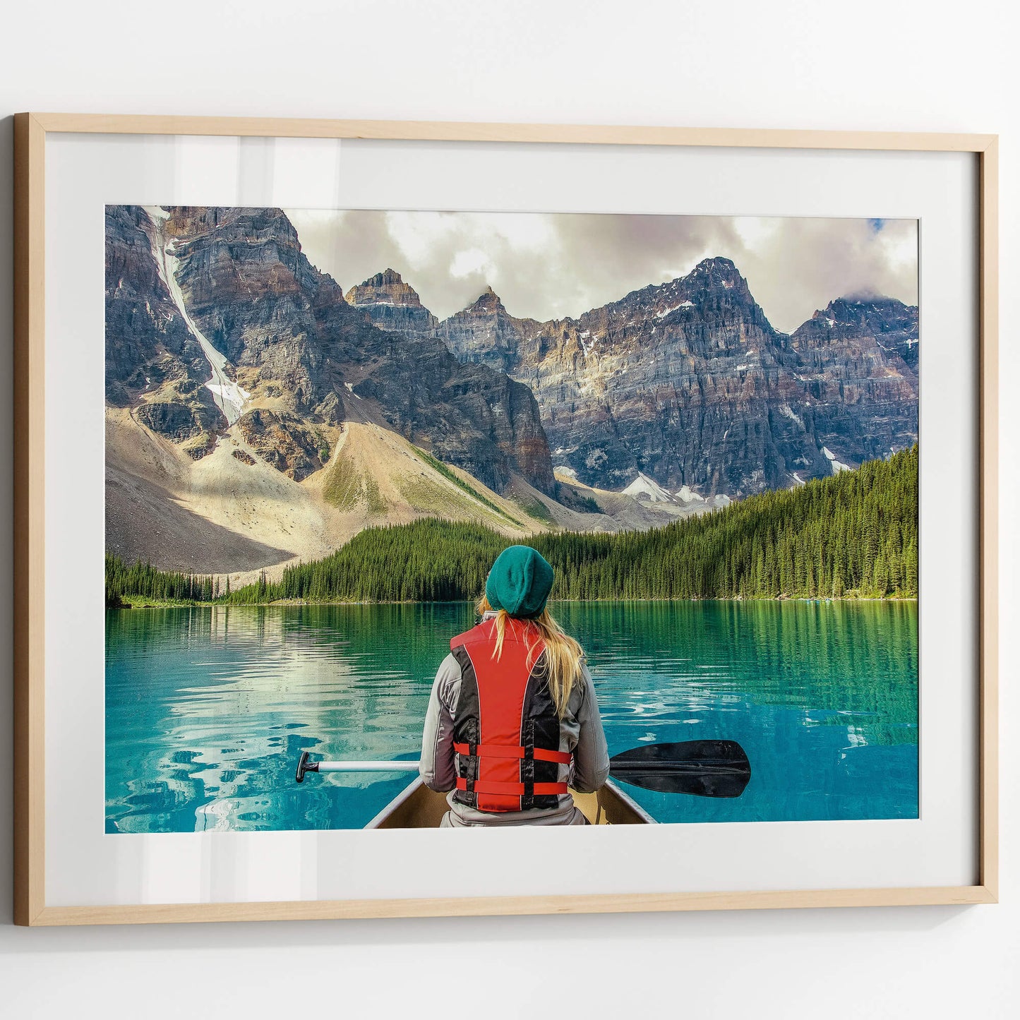 A framed Mountain Canoeing Print displayed on a white wall, enhancing a modern interior space.