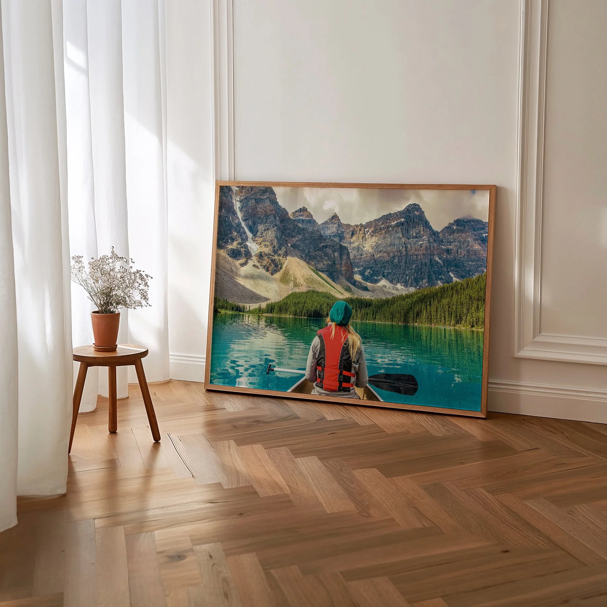 A white-framed Mountain Canoeing Print styled in a minimalist decor setting.