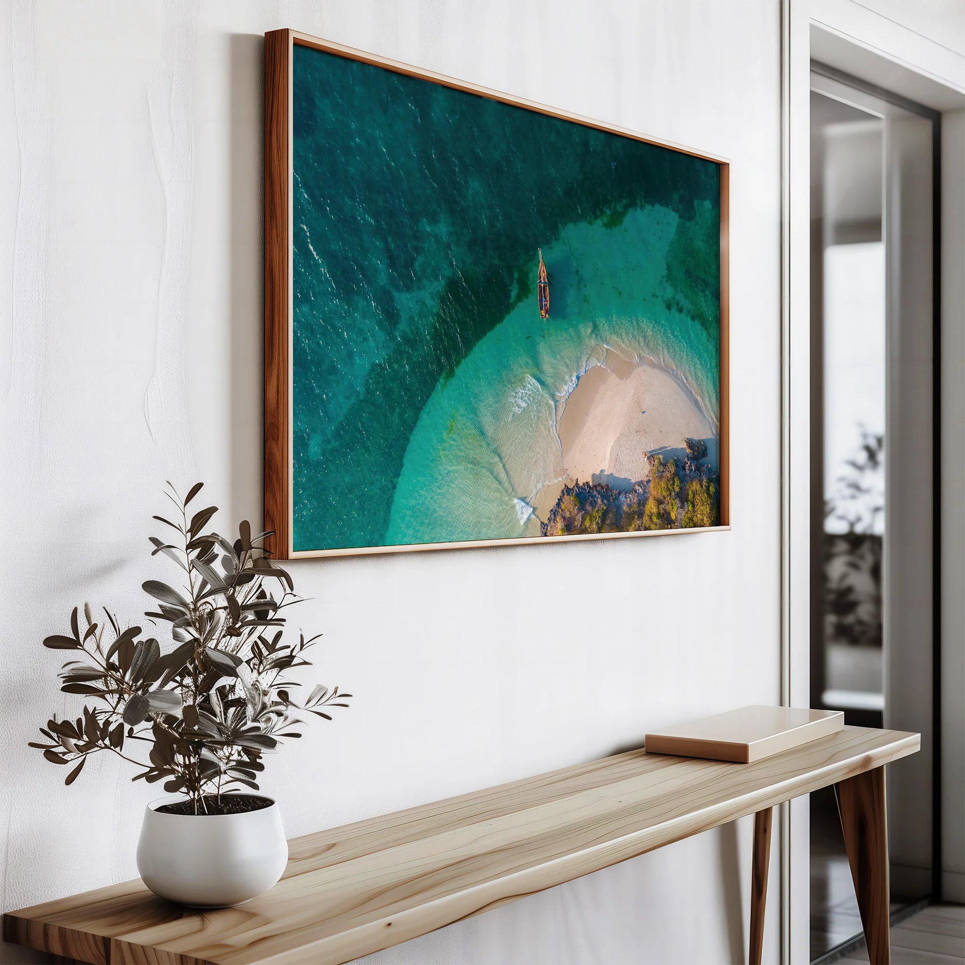 A framed Secluded Beach Print placed on a desk, bringing a touch of tropical beauty into an interior space.