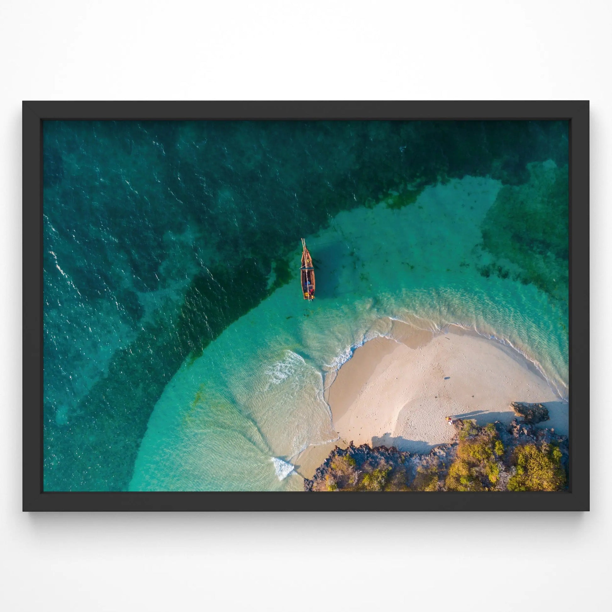 A breathtaking aerial view of a secluded beach with a small wooden boat floating in clear turquoise waters. The golden sand curves around the shoreline, creating a natural cove.