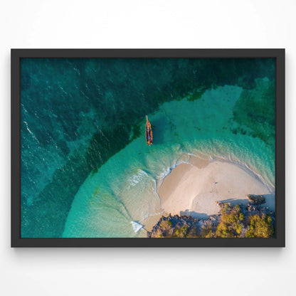 A breathtaking aerial view of a secluded beach with a small wooden boat floating in clear turquoise waters. The golden sand curves around the shoreline, creating a natural cove.