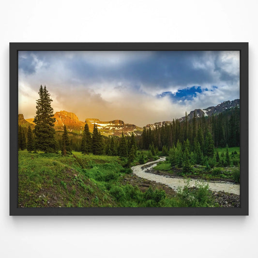A print of a golden-lit mountain landscape resting on a minimalist desk, complementing a contemporary setting.