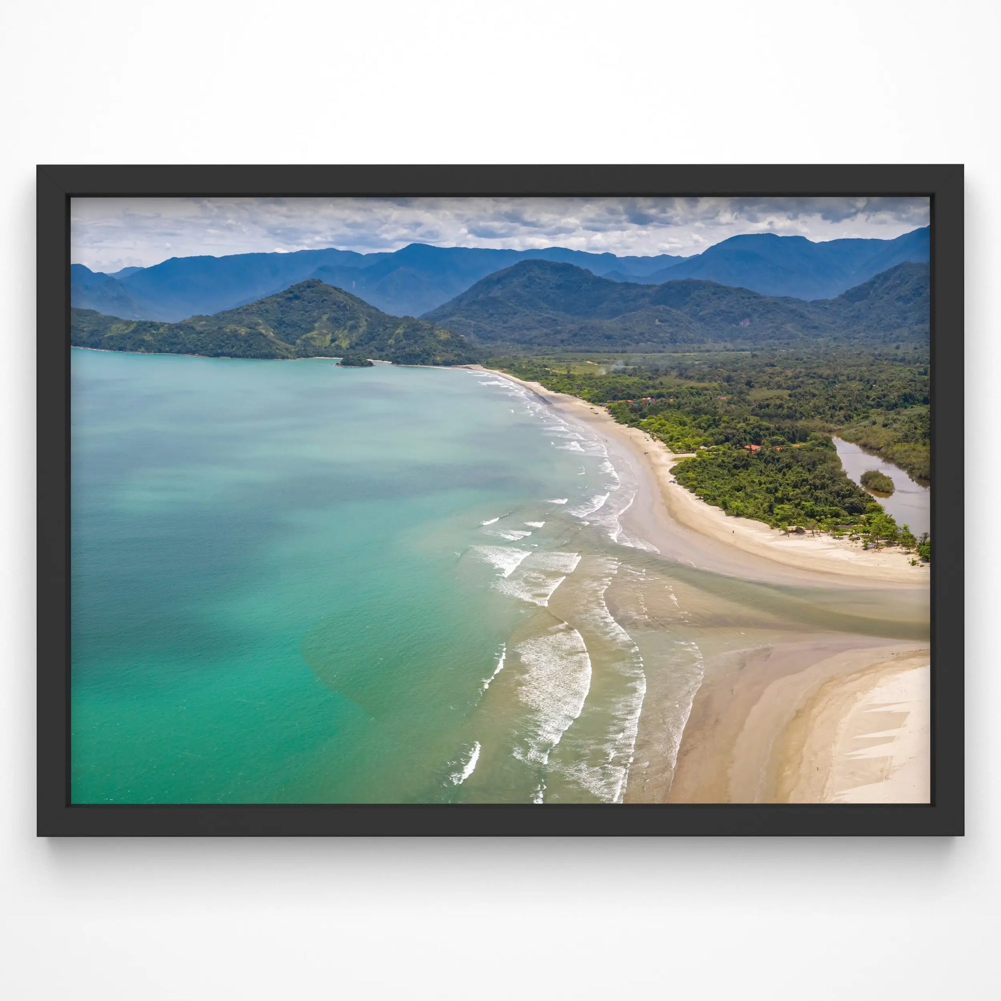 A breathtaking aerial view of a tropical beach with turquoise waters, golden sand, and lush green mountains in the background.