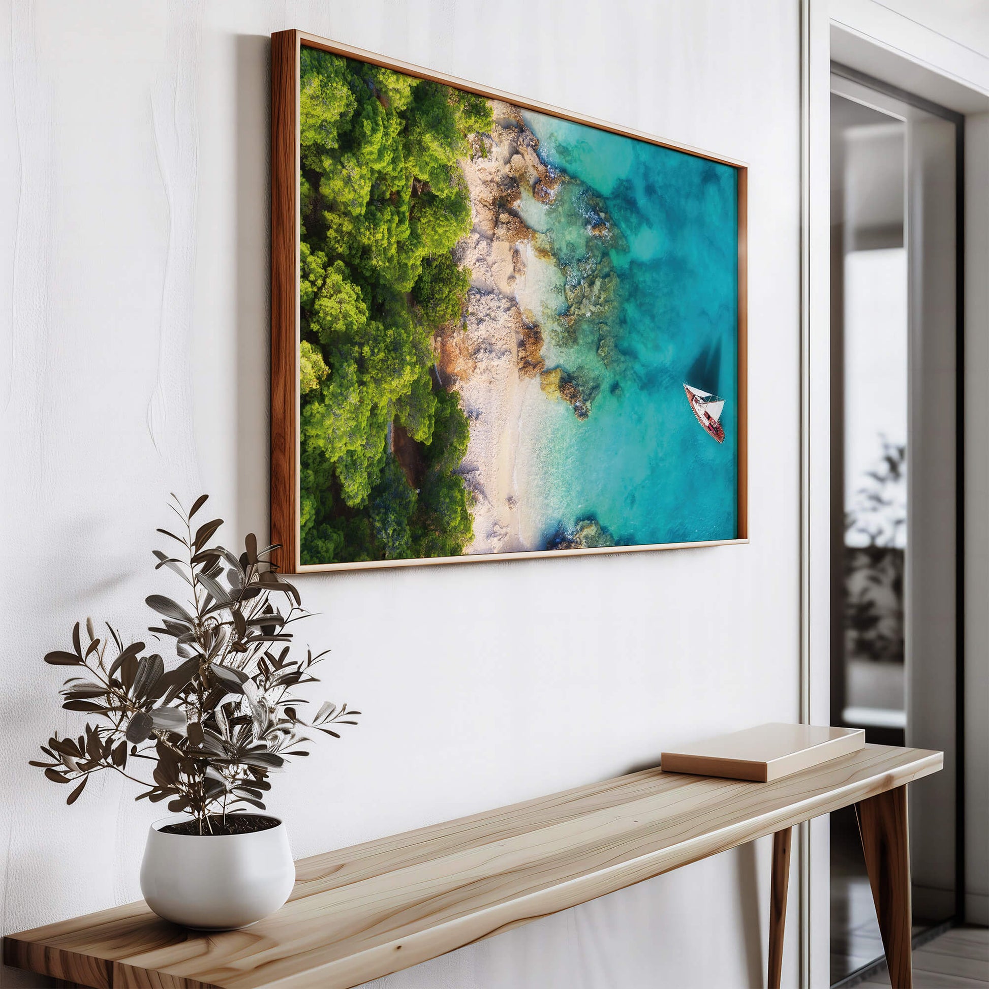 A modern space featuring the Tropical Coastline Print, framed and hung above a wooden console table for a minimalist look.