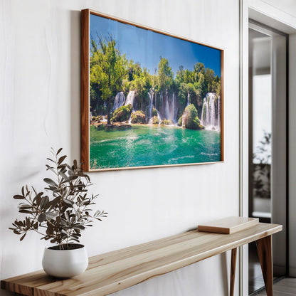 The Waterfall Oasis Print leaning against a white wall on a shelf, ready to be hung in any space.