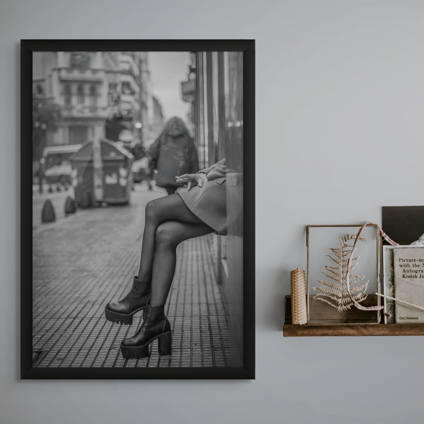 Stylish woman in platform boots sitting on city curb